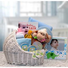 a baby's gift basket on a table next to a photo frame and stuffed animal