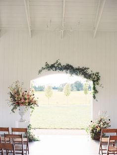 the aisle is decorated with flowers and greenery for an outdoor ceremony at this farm