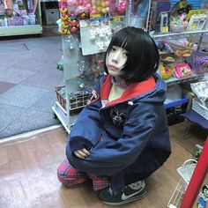 a mannequin sitting on the ground in front of a store