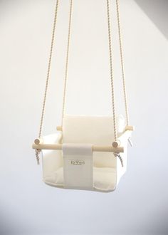 a white swing chair hanging from a rope