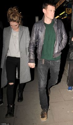 a man and woman walking down the street at night