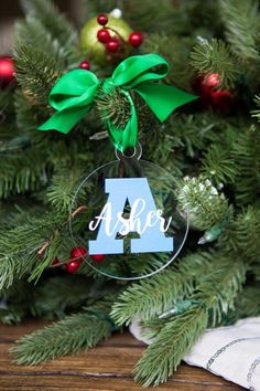 a glass ornament with the letter a on it hanging from a christmas tree