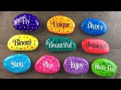 painted rocks with names on them sitting on a wooden table in the shape of eggs