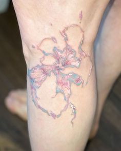 a close up of a person's legs with flowers on them and water splashing all over the leg