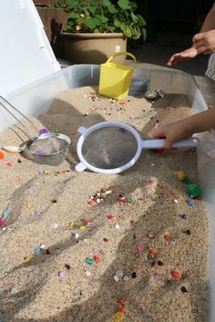 two children are playing with sand in an outdoor play area