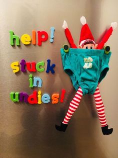 an elf hanging on the wall with words help stuck in undies