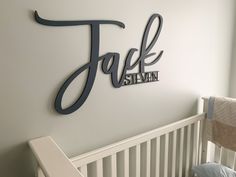 a baby's room with a crib and name sign