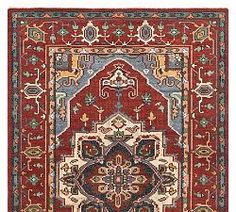 a red and blue rug with an ornate design on the center, surrounded by other decorative elements