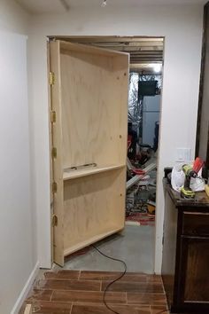 an empty room with wood floors and a large wooden cabinet in the corner that is being worked on