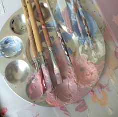 some paint brushes and spoons on a plate