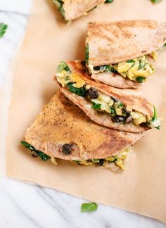 three quesadillas stacked on top of each other with eggs and spinach