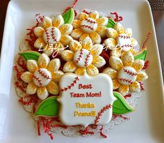 decorated cookies on a white plate with the words best team mom in red and yellow