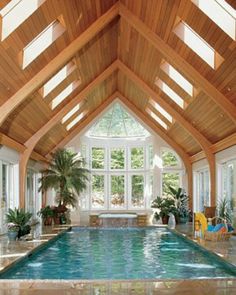 a large indoor swimming pool in the middle of a room with high ceilings and windows