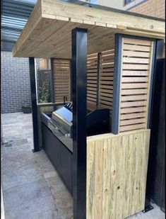 an outdoor bbq with wood slats on the sides and grilling area next to it