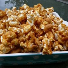 a bowl full of caramel popcorn sitting on top of a table