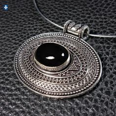 Elegant Black Onyx  & .925 Plated Silver Pendant  ⚜ Pendant Length: 1 3/4 inches  ⚜ Necklace length: 18 inches ⚜  Stainless Steel Choker ⚜ Screwed Clasp ⚜ Weight: 18.1 g ⚜  Pictures taken under profesionnal studio lights.  As if they were pictured outside under the blue sky of a sunny day.  According to your monitor settings, colors may slightly vary. ⚜  Like any natural stones, this one could have some minor flaws The Craftsman Advantage with BijouxQuebec: You don't like the clasp of a bracelet? The hooks of a pair of earrings don't suit you? You find a necklace too long? Not long enough? No problem at all! Spot in my shop what you would have preferred and if possible, I will make the change for you, most of the time quite free. Traditional Black Engraved Necklace, Black Hallmarked Round Pendant Necklace, Black Round Pendant Necklace, Traditional Black Hallmarked Jewelry, Antique Black Sterling Silver Necklace, Antique Black Necklace With Oxidized Finish, Black Hallmarked Round Necklaces, Black Necklace With Oxidized Finish, Black Jewelry With Oxidized Finish Round Pendant