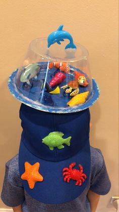 a child wearing a hat with toys on it's top and under the lid