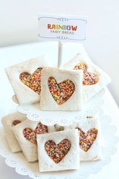 small sandwiches with sprinkles in the shape of hearts on a white plate