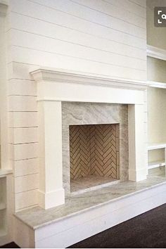 an empty room with a fireplace and shelves