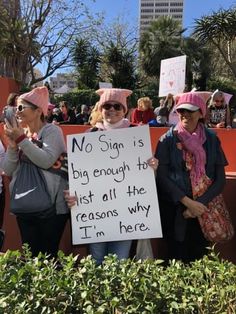 two women holding a sign that says no sign is big enough to just all the reason why i'm here