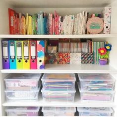 a book shelf filled with lots of books and plastic containers on top of each other