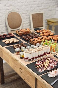 a table topped with lots of desserts and drinks next to other foods on top of it