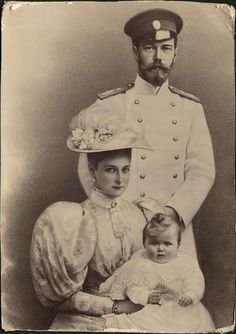 an old black and white photo of a man in uniform with two women holding a baby