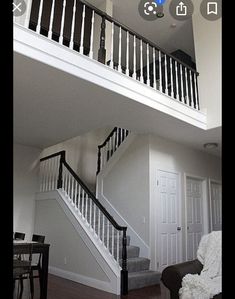 a living room filled with furniture and a stair case next to a dining table on top of a hard wood floor