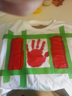 a child's handprint on a t - shirt with green and red strips