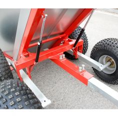 a red trailer with two wheels attached to the side and another wheel on the other side