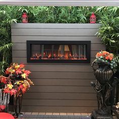 a fire place in the corner of a house with potted plants next to it