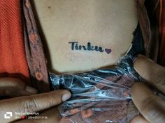 a woman with a tattoo that says tinker on her stomach