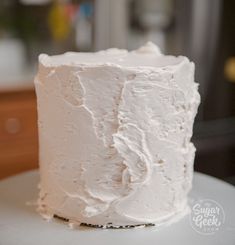 a white frosted cake sitting on top of a table