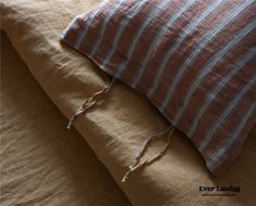 two pillows on top of each other with string tied to the pillow and corded ends