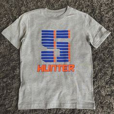 a t - shirt that says hunter on it sitting on the floor in front of some carpet