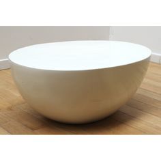 a white bowl sitting on top of a wooden floor