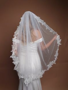 a woman wearing a white veil and wedding dress