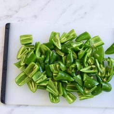 chopped green peppers on a white cutting board