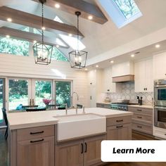 a large kitchen with an island and skylight above it is featured in the magazine learn more