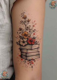 a woman's arm with flowers and books tattoo on the left side of her body