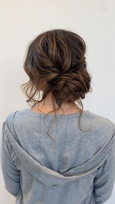 the back of a woman's head with her hair in a low bun