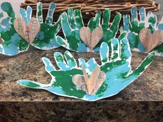 several handprints made to look like leaves on a granite counter top with a basket in the background