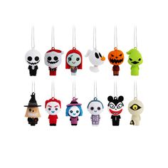 a group of small ornaments hanging from strings on a white background with an image of cartoon characters in different colors