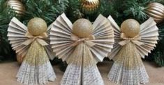 three paper angel ornaments sitting on top of a table