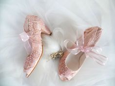 two pairs of pink ballet shoes with bows and pearls on the toes, one is for brides