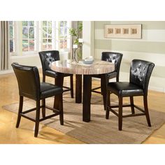 a dining room table with four chairs and a vase on top of it in front of a window