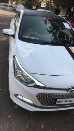 a white car is parked on the side of the road with an orange stripe painted on it