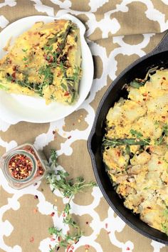 an omelet in a cast iron skillet next to a bowl of seasoning