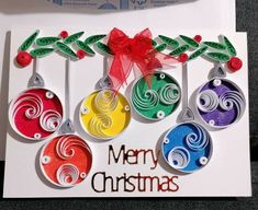 a card with christmas ornaments hanging from it's sides and the words merry christmas