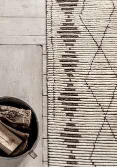 a bowl filled with wood sitting on top of a rug